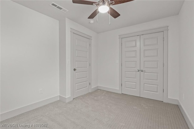 unfurnished bedroom featuring a closet, ceiling fan, and light colored carpet