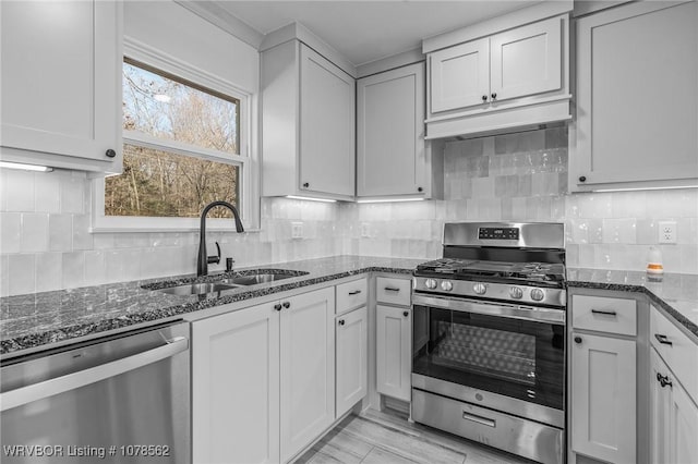 kitchen featuring sink, white cabinets, appliances with stainless steel finishes, and dark stone counters