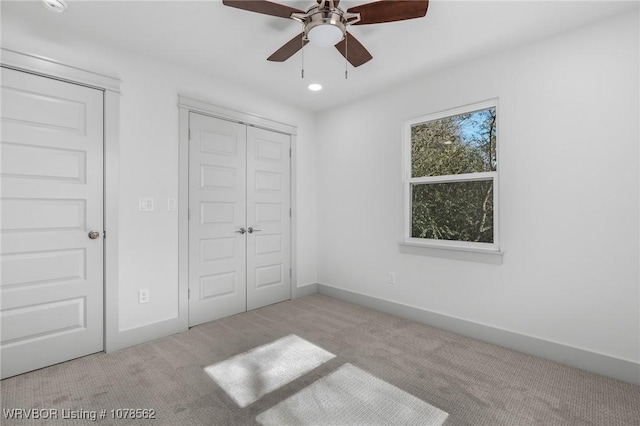 unfurnished bedroom with ceiling fan and light carpet