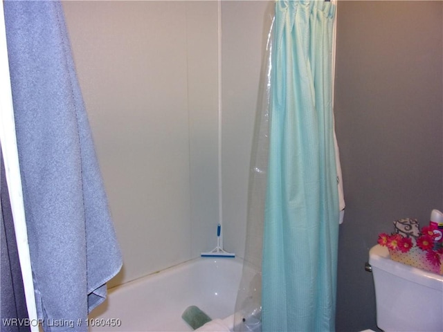 bathroom featuring shower / bath combo and toilet