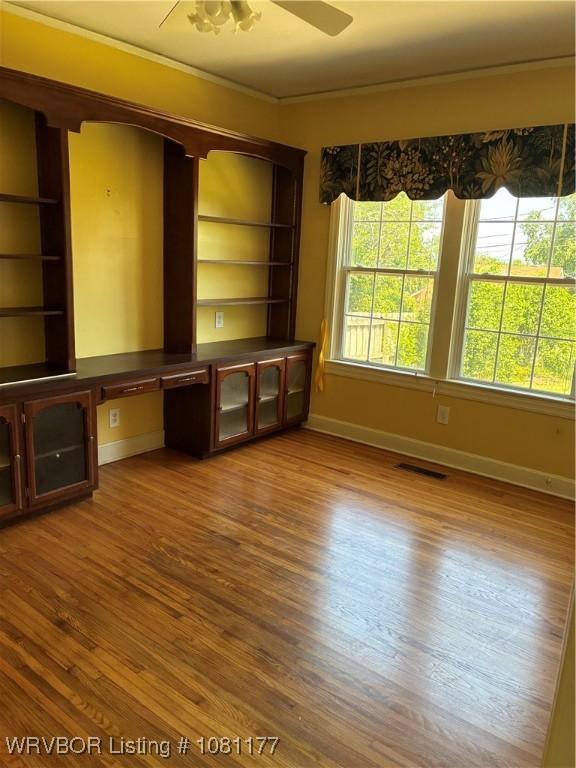 2227 S Q St, Fort Smith, AR 72901 - unfurnished living room featuring baseboards, wood finished floors, and a ceiling fan