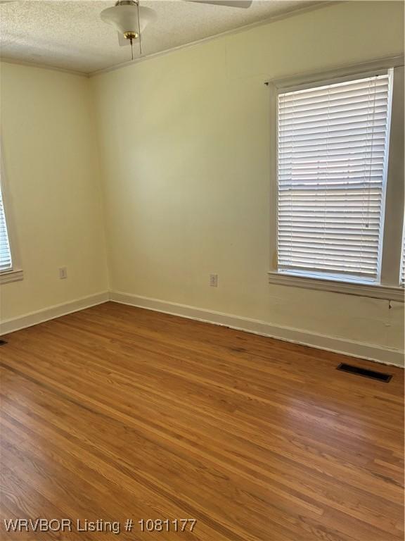 2227 S Q St, Fort Smith, AR 72901 - empty room with wood finished floors, baseboards, a textured ceiling, and crown molding
