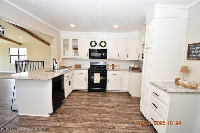 kitchen featuring black appliances, a sink, a peninsula, white cabinets, and glass insert cabinets