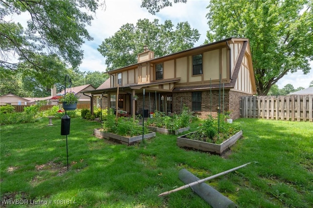 2508 Roxbury Ln, Fort Smith, AR 72908 - rear view of property featuring a chimney, a vegetable garden, stucco siding, and brick siding