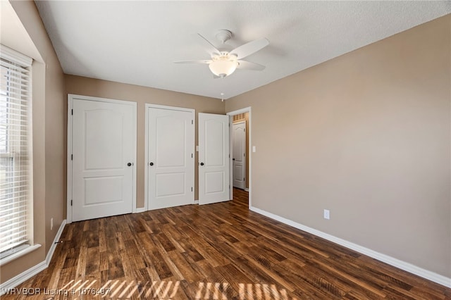 unfurnished bedroom with ceiling fan and dark hardwood / wood-style flooring