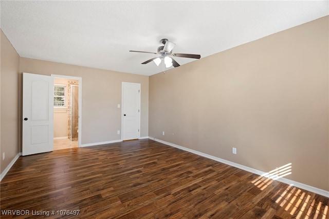 unfurnished bedroom featuring ceiling fan, dark hardwood / wood-style floors, and connected bathroom