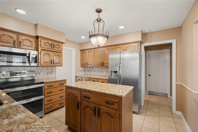 kitchen with decorative light fixtures, a center island, stainless steel appliances, and tasteful backsplash