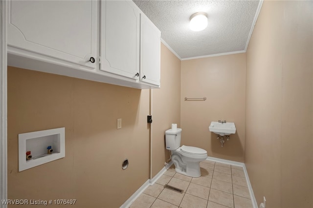 bathroom featuring crown molding, sink, tile patterned flooring, toilet, and a textured ceiling