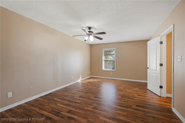 empty room with ceiling fan, dark hardwood / wood-style flooring, and a textured ceiling