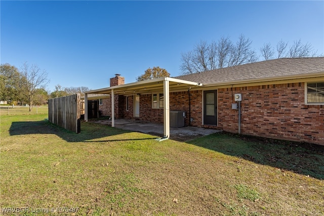 back of house featuring a patio, a yard, and central AC