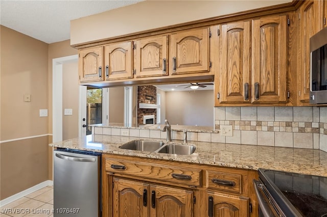 kitchen featuring sink, decorative backsplash, ceiling fan, light tile patterned floors, and stainless steel appliances