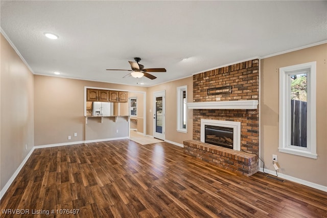 unfurnished living room featuring a fireplace, ceiling fan, and dark wood-type flooring