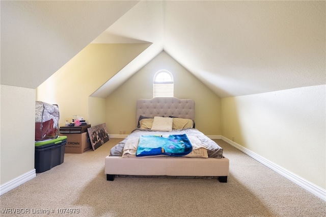 bedroom with carpet floors and vaulted ceiling