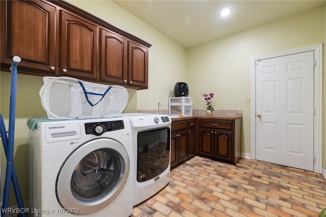 laundry area featuring washing machine and clothes dryer, sink, and cabinets