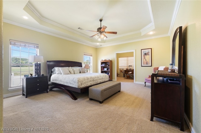 carpeted bedroom with multiple windows, a raised ceiling, ceiling fan, and ornamental molding