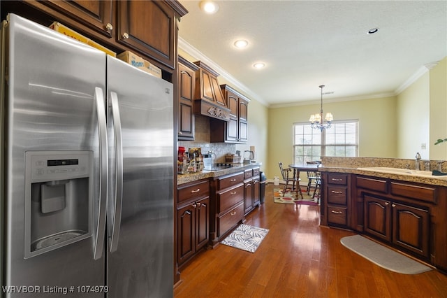 kitchen featuring dark wood-type flooring, an inviting chandelier, sink, decorative light fixtures, and stainless steel fridge with ice dispenser