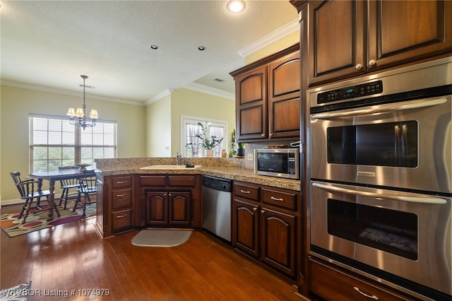 kitchen featuring ornamental molding, appliances with stainless steel finishes, sink, and dark hardwood / wood-style flooring