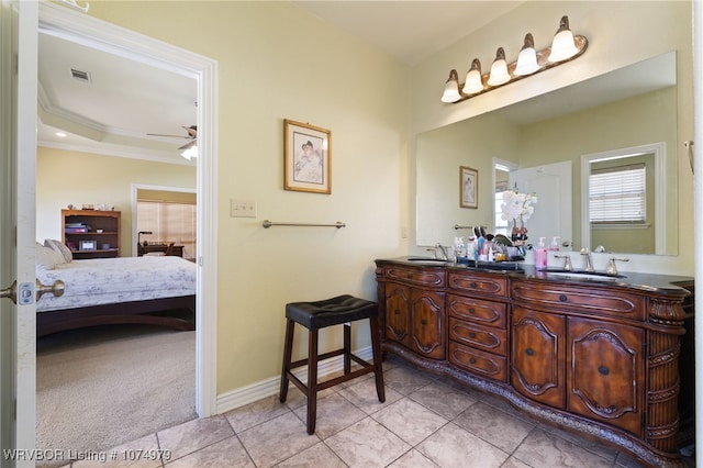 bathroom with ceiling fan, a raised ceiling, tile patterned floors, crown molding, and vanity