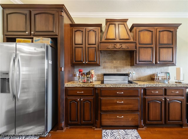 kitchen with stainless steel refrigerator with ice dispenser, decorative backsplash, ornamental molding, and custom range hood