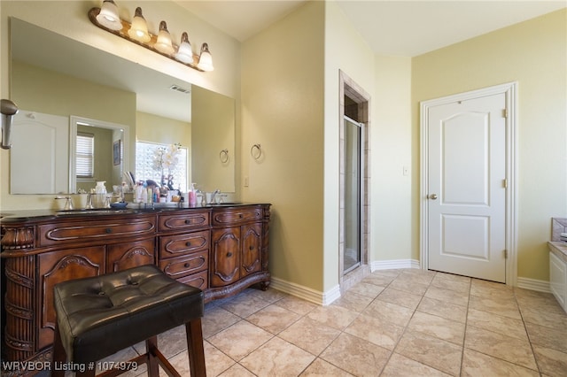 bathroom featuring tile patterned flooring, vanity, and a shower with door