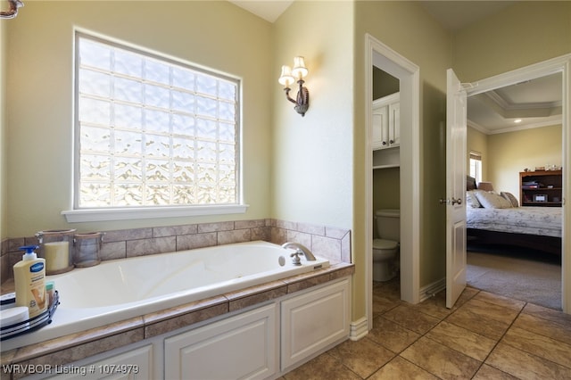 bathroom with a bathtub, tile patterned floors, crown molding, toilet, and a tray ceiling