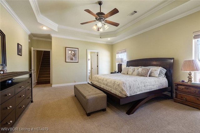 carpeted bedroom featuring ceiling fan, a raised ceiling, and ornamental molding