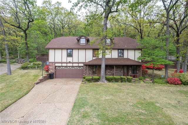 english style home featuring a front yard and a garage