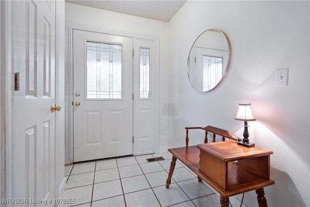 entrance foyer with light tile patterned floors and a textured ceiling