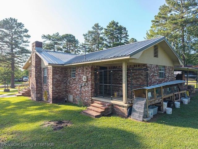 6810 Robin Way, Ozark, AR 72949 - rear view of house with a lawn, a chimney, a metal roof, brick siding, and entry steps