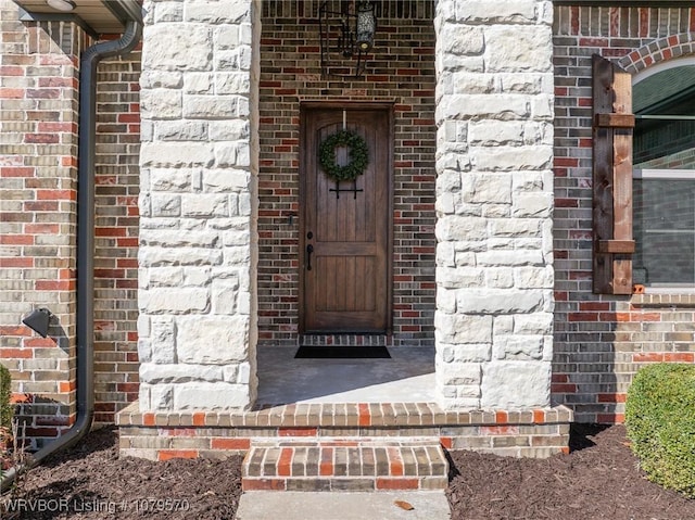 doorway to property with brick siding