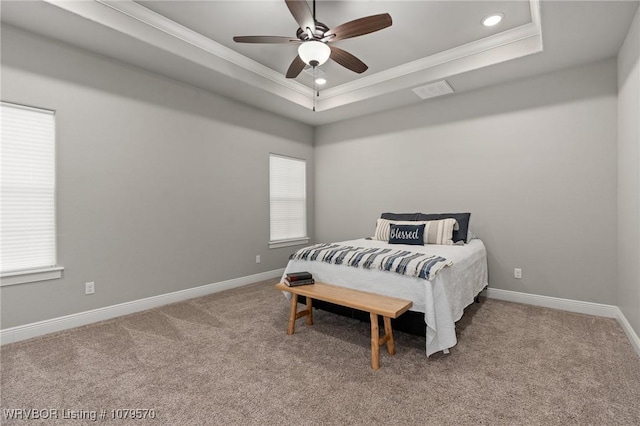 bedroom with carpet flooring, a raised ceiling, and baseboards