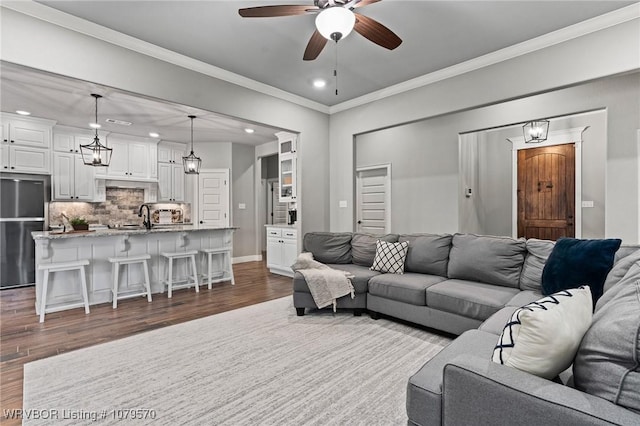 living room with dark wood-style floors, baseboards, recessed lighting, ceiling fan, and ornamental molding