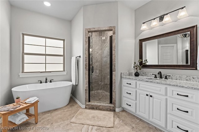 bathroom with a soaking tub, baseboards, vanity, and a shower stall