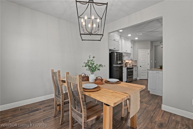 dining space featuring dark wood-style floors, a notable chandelier, recessed lighting, and baseboards