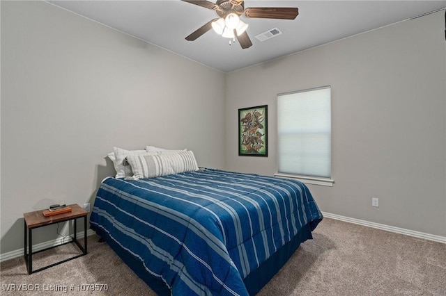 carpeted bedroom with visible vents, baseboards, and ceiling fan