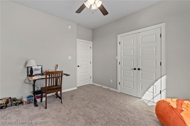 carpeted home office featuring baseboards and ceiling fan