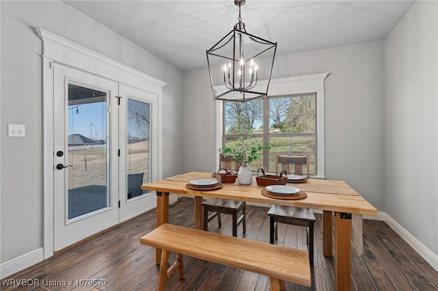 dining area featuring an inviting chandelier, baseboards, and dark wood-style flooring