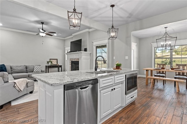 kitchen featuring a sink, open floor plan, a stone fireplace, built in microwave, and dishwasher