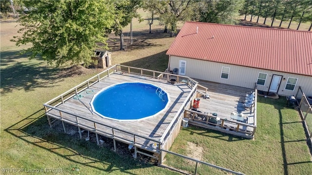view of pool with a wooden deck and a yard