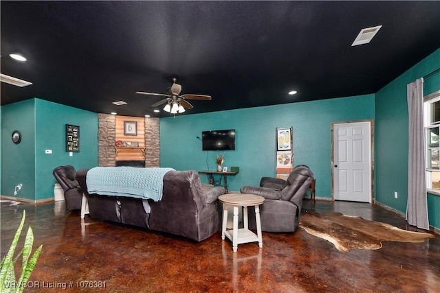 cinema with a stone fireplace and ceiling fan