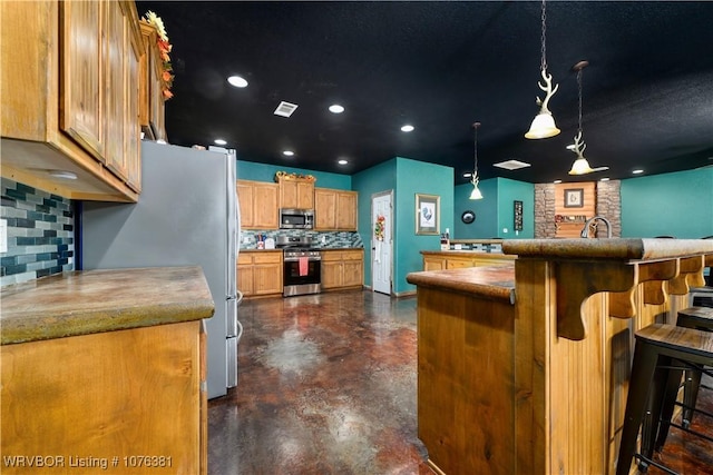 kitchen featuring hanging light fixtures, a kitchen breakfast bar, tasteful backsplash, and stainless steel appliances