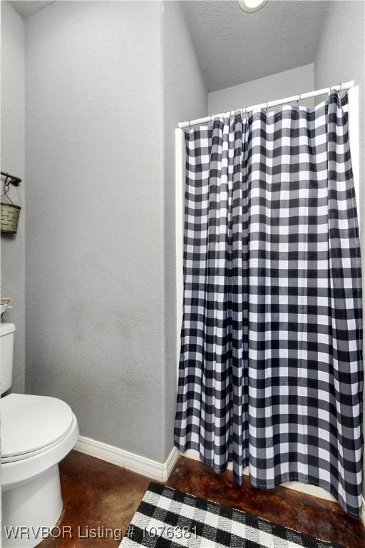 bathroom featuring a textured ceiling and toilet