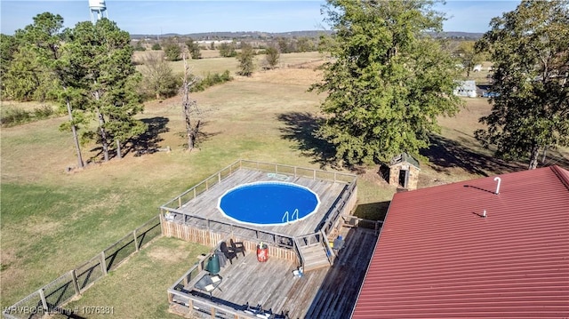 view of swimming pool with a rural view