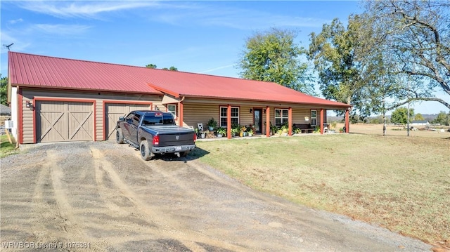 single story home with covered porch, a garage, and a front lawn