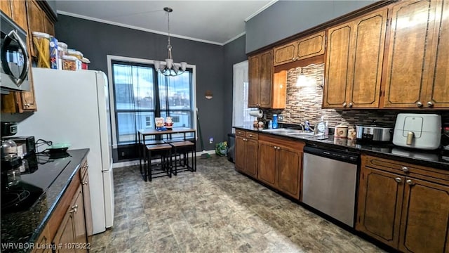 kitchen with sink, hanging light fixtures, ornamental molding, stainless steel appliances, and a chandelier