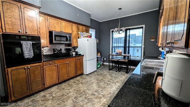 kitchen featuring sink, decorative light fixtures, a notable chandelier, white fridge, and black oven