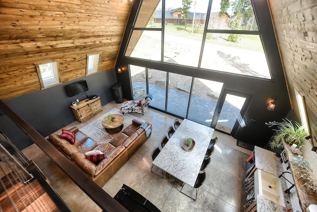 unfurnished living room with wood walls and a high ceiling