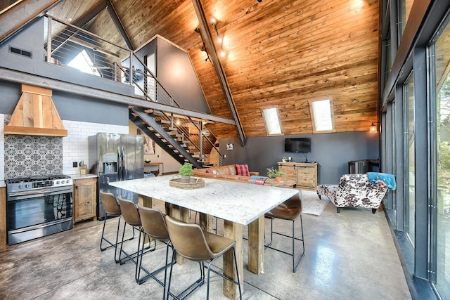 kitchen with stainless steel appliances, high vaulted ceiling, custom exhaust hood, a kitchen bar, and wooden ceiling