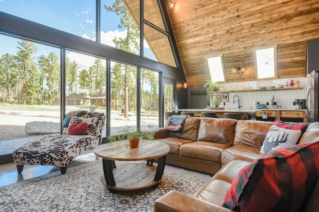 tiled living room featuring wooden ceiling, wood walls, a skylight, high vaulted ceiling, and sink