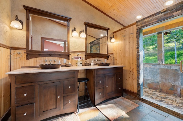 bathroom featuring wooden walls, oversized vanity, tile flooring, and a shower